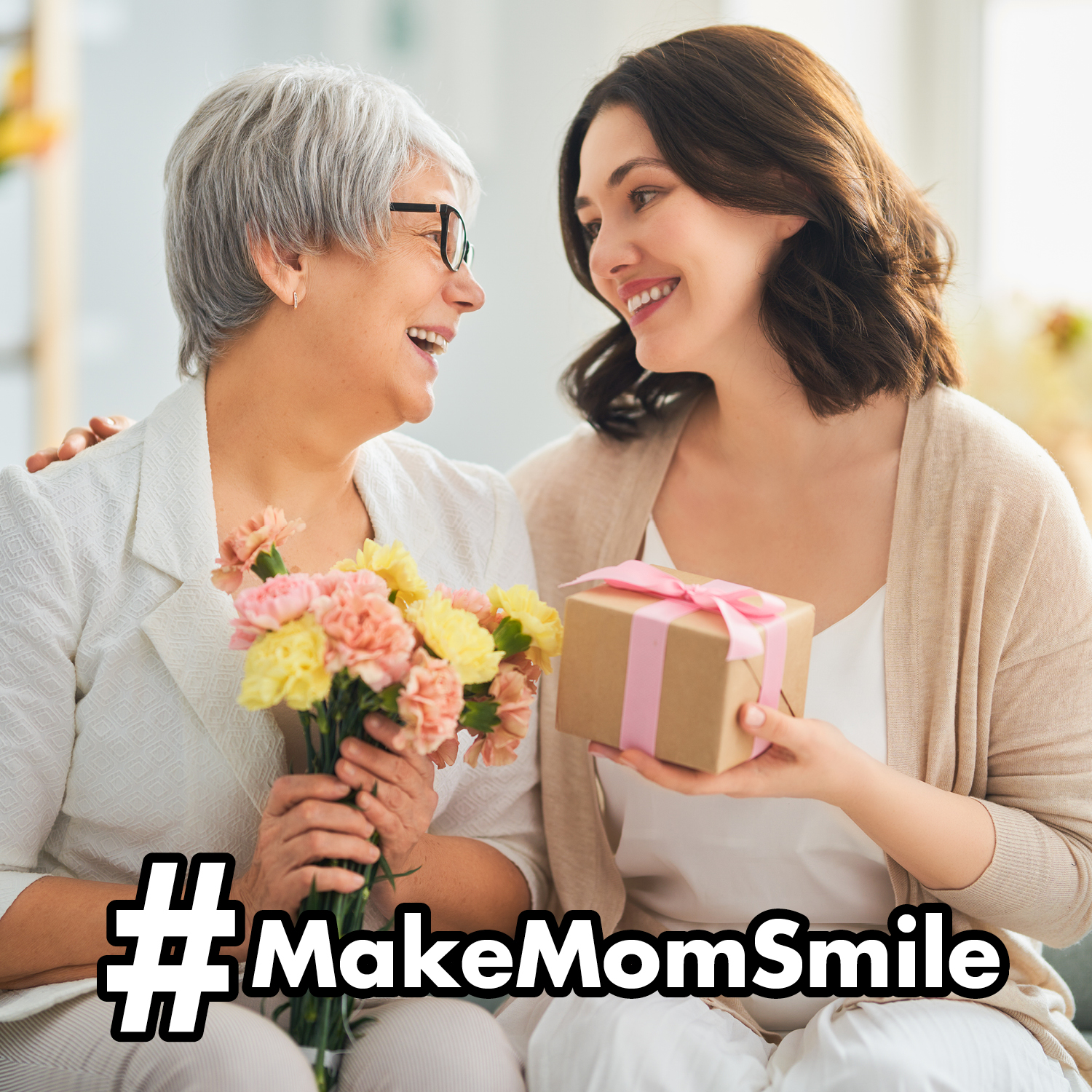 adult daughter gifting mom flowers and a small gift #MakeMomSmile