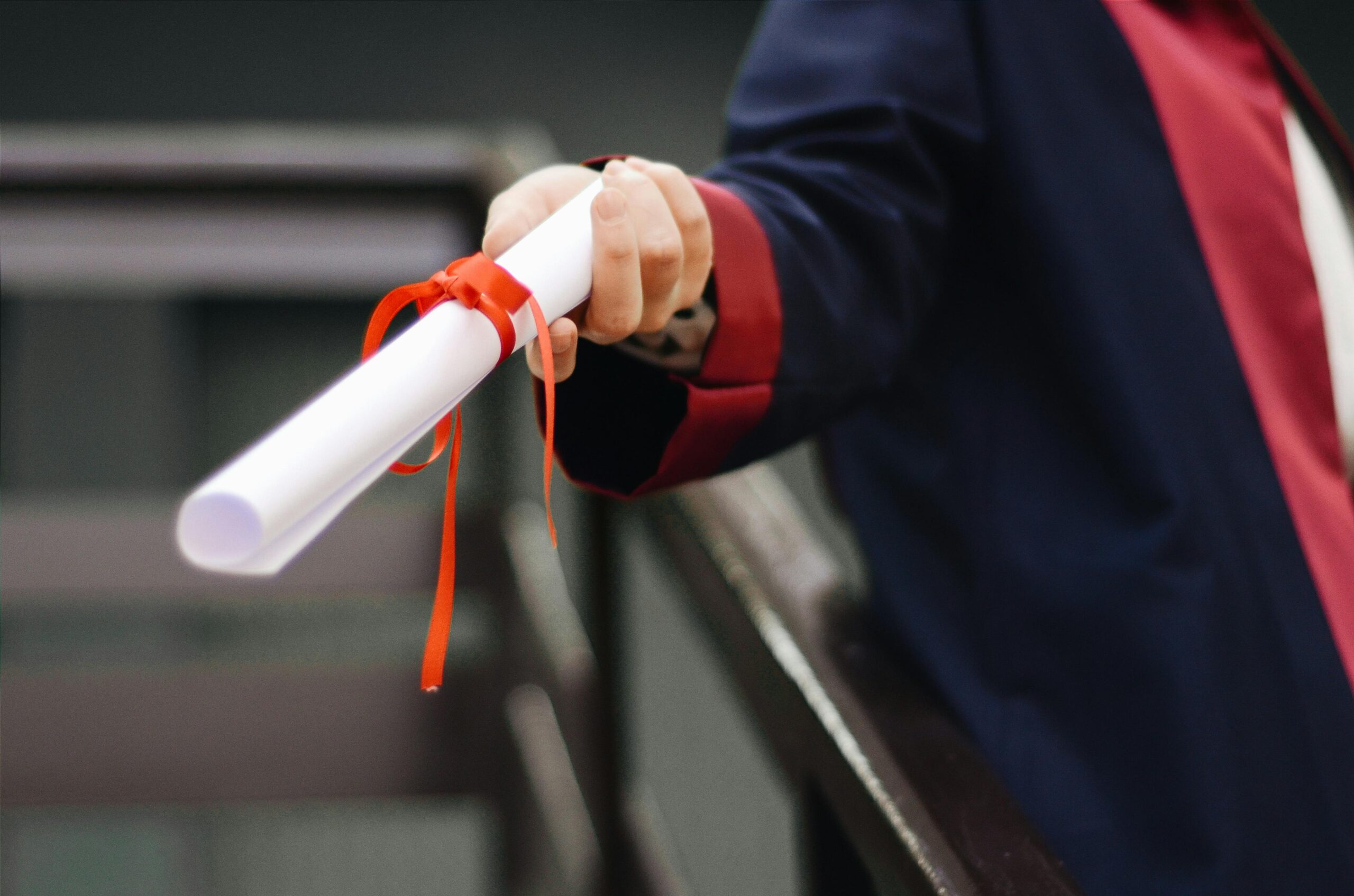 Person giving out diploma during a graduation.