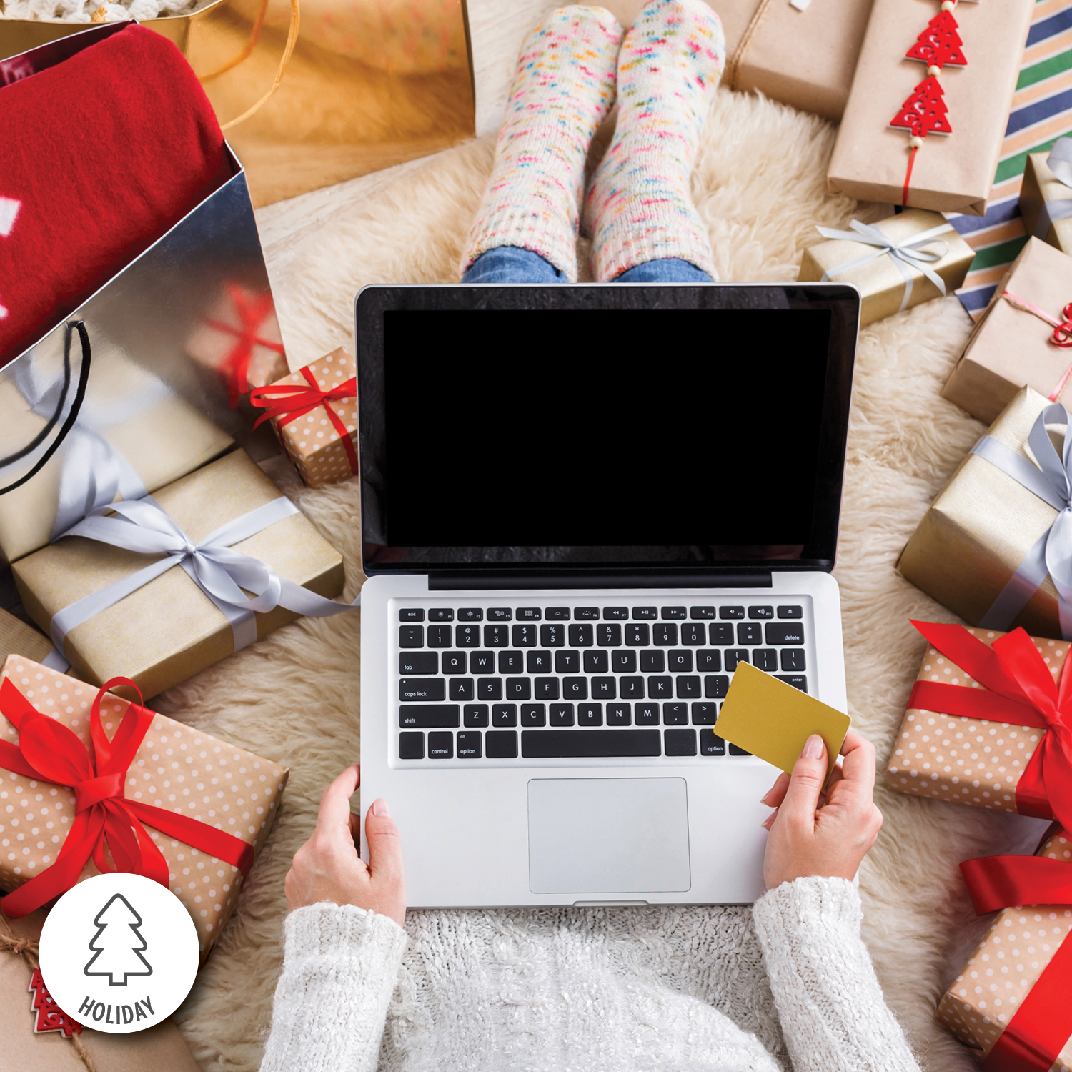 Person with debit card and laptop Holiday Shopping; Is surrounded by presents