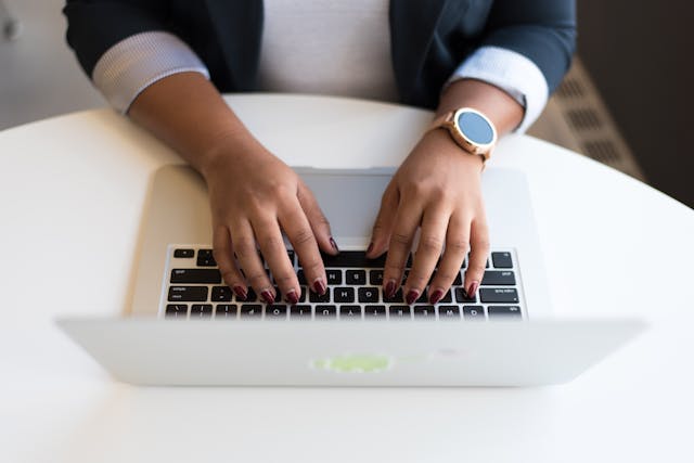 Closeup of someone typing on a laptop