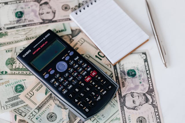 Table covered with money, notepads, and calculator