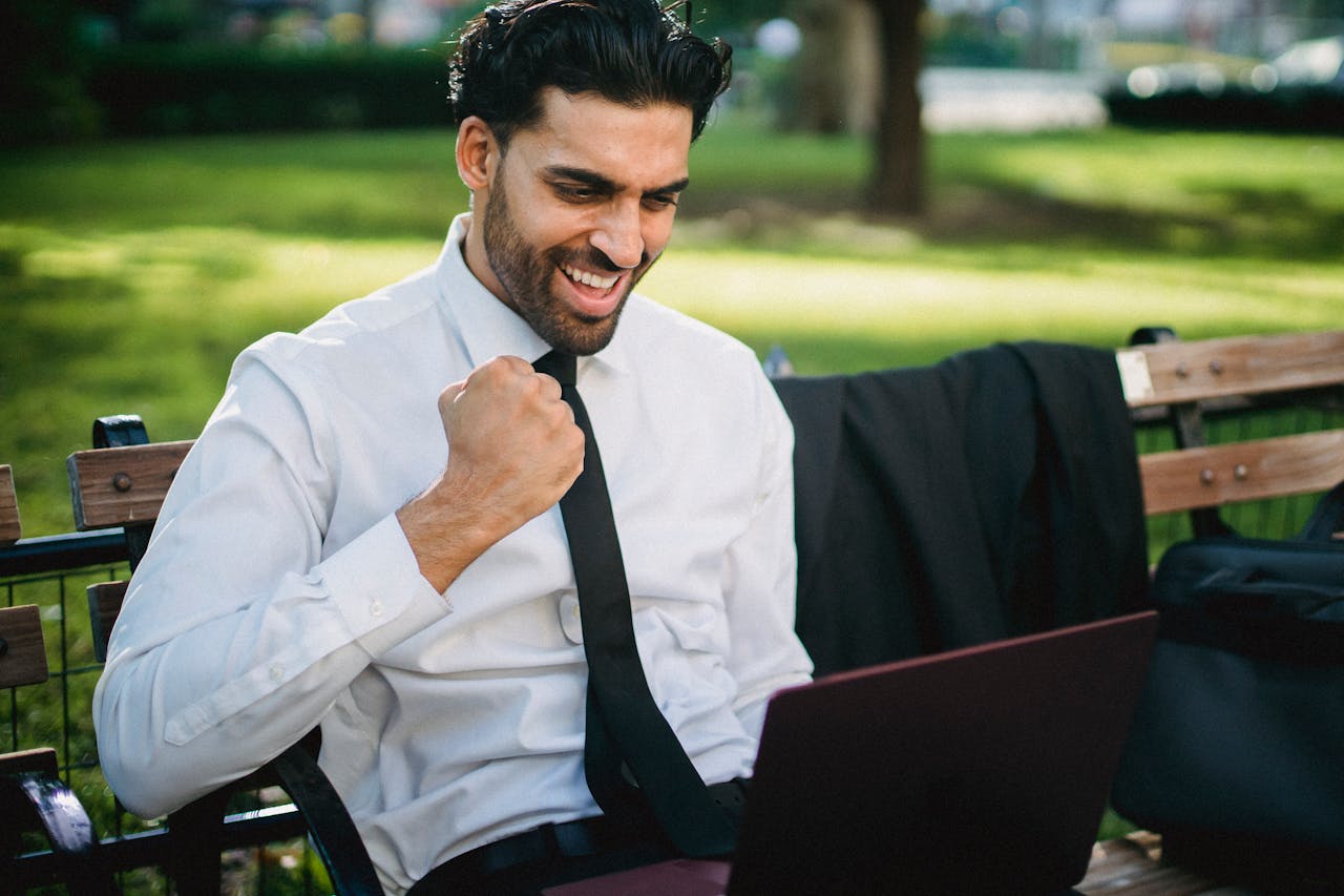 Excited businessperson cheering while on their laptop