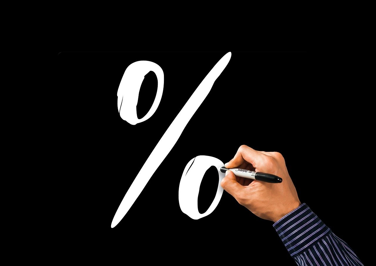 Person drawing percent symbol with marker.